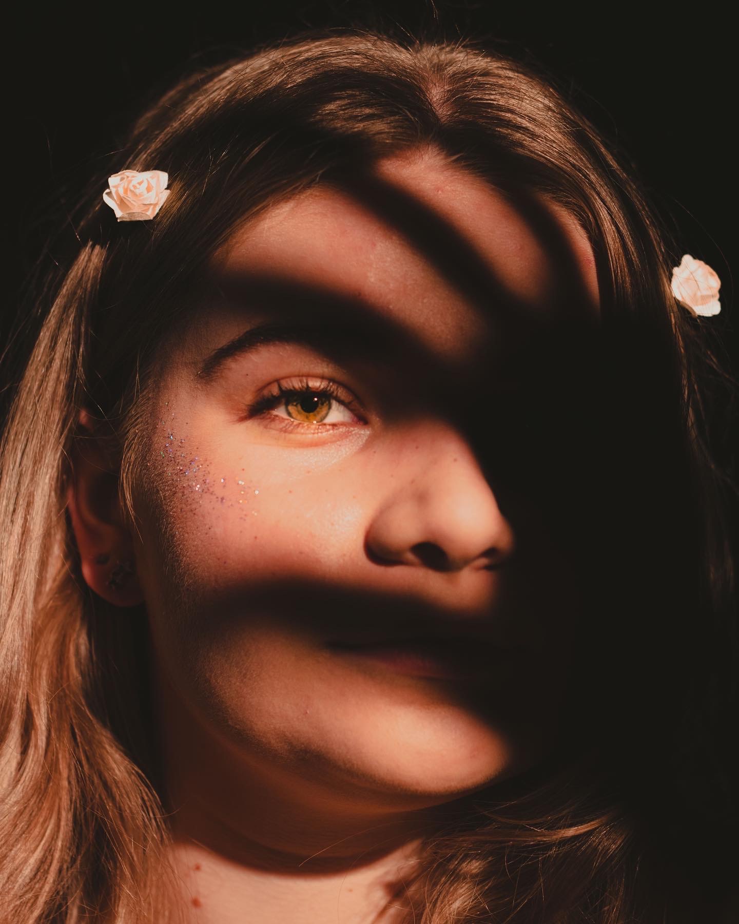 Photo of a girl with her hand making a shadow over her face